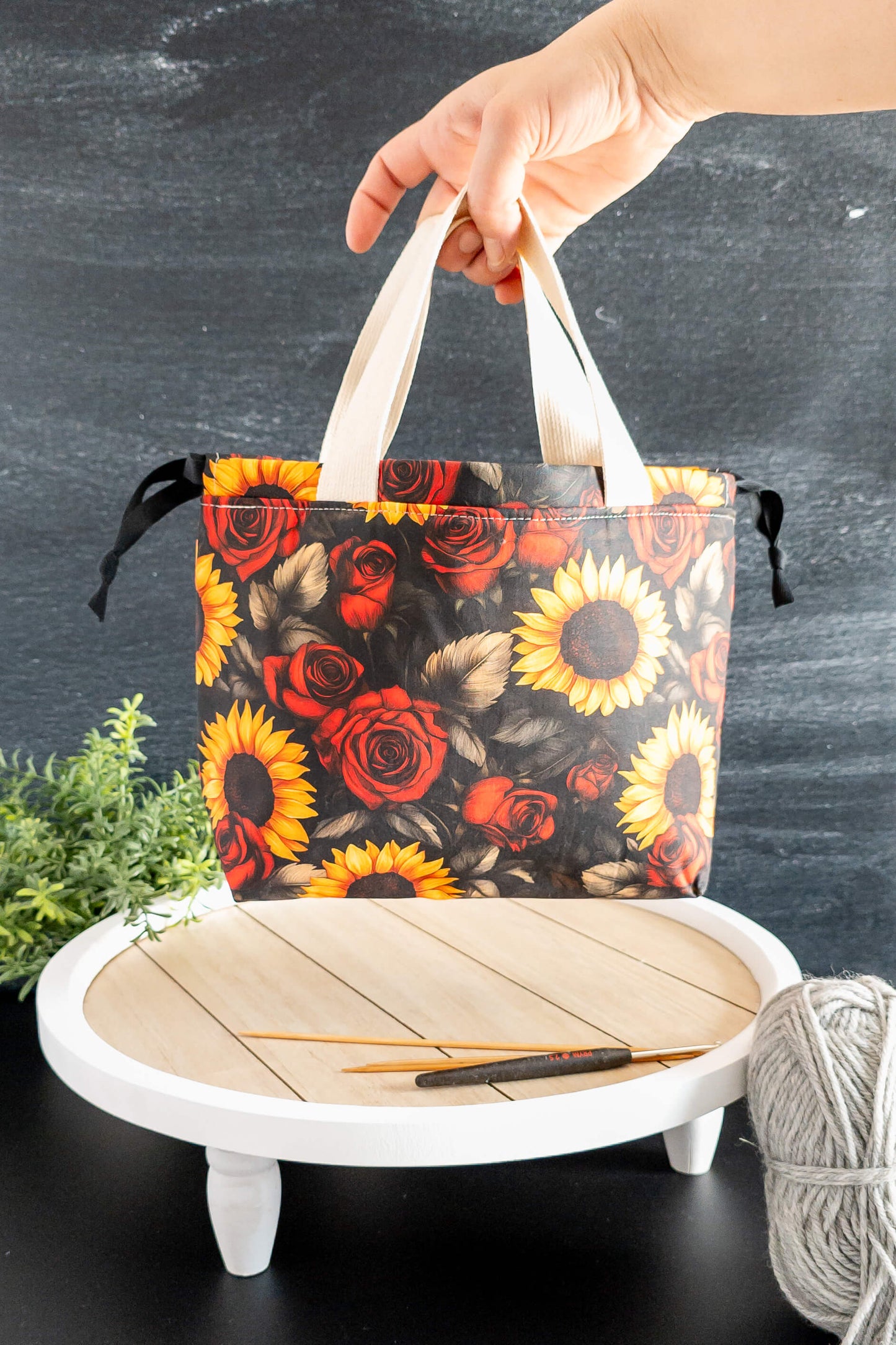 Nahaufnahme der Sonnenblumen und roten Rosen auf dem Baumwollstoff der Alva Bag