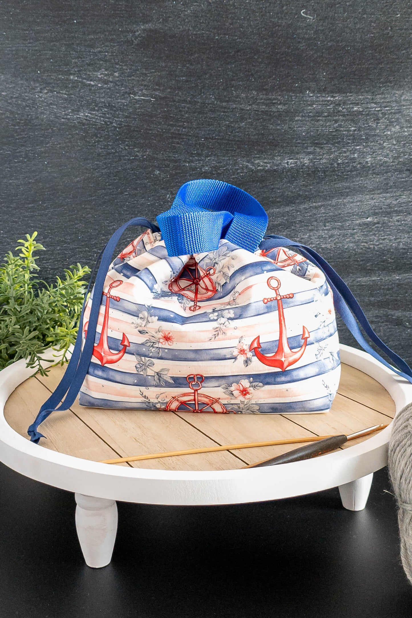Seaside Stitch Projekttasche in Szene gesetzt mit Garn und Häkelnadel – perfekt als Field Bag.