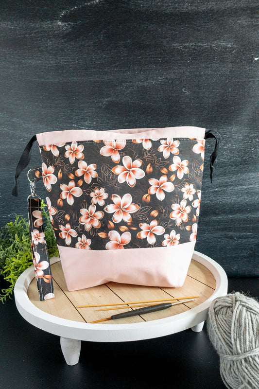 Detailaufnahme der handgenähten Stricktasche mit zarten Blüten in Weiß und Apricot