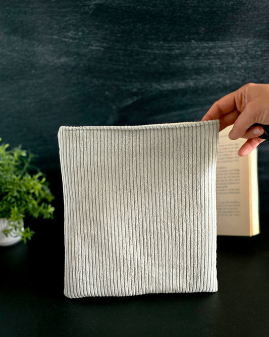 Buchhülle aus mintfarbenem Cord vor schwarzem Hintergrund