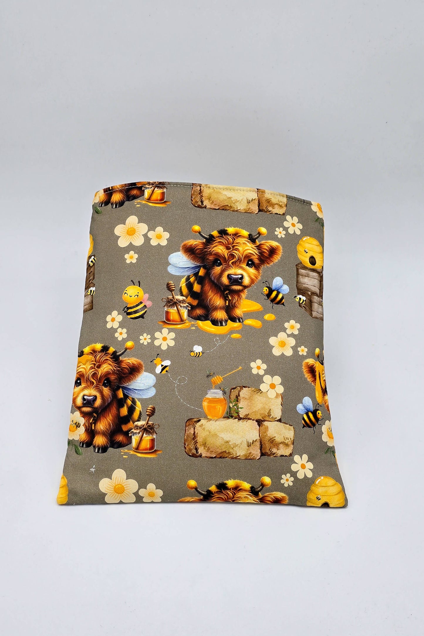 Buchhülle in Nutzung mit einem aufgeklappten Buch, zeigt die flexible Passform für Taschen- und Hardcoverbücher