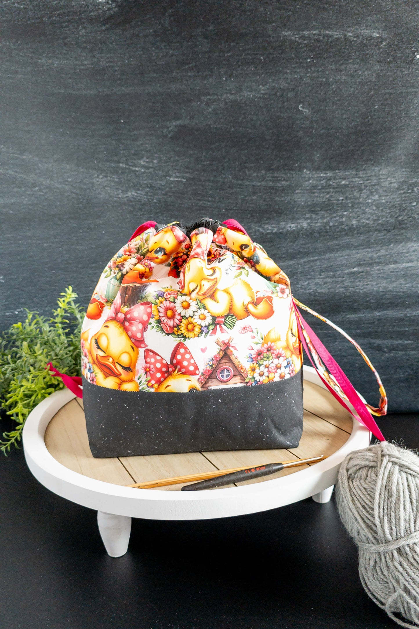 Projekttasche auf weißem Tisch mit Stricknadel und Garn – charmante Aufbewahrungslösung