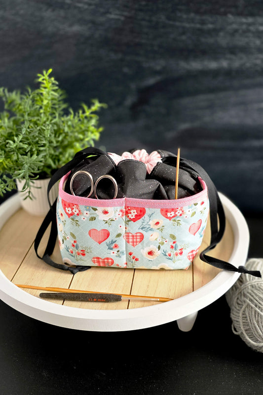 Handgenähte Projekttasche mit Herzmotiv, gefüllt mit Strickzubehör – perfekt für kleine Strick- und Häkelprojekte unterwegs und zuhause.