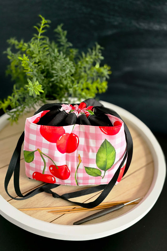 Stricktasche „Kirschenzeit“ mit Kordelzug, gefüllt mit Wolle und Nadeln, von oben fotografiert