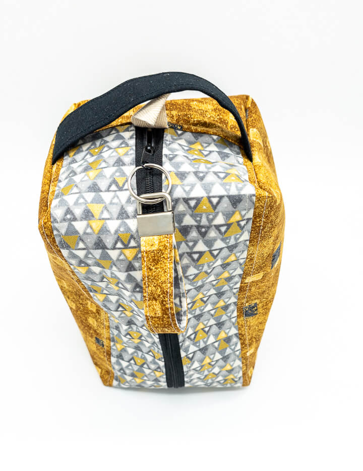 Handgenähte Projekttasche im goldenen Design mit geometrischen Mustern, ideal für Strickprojekte.