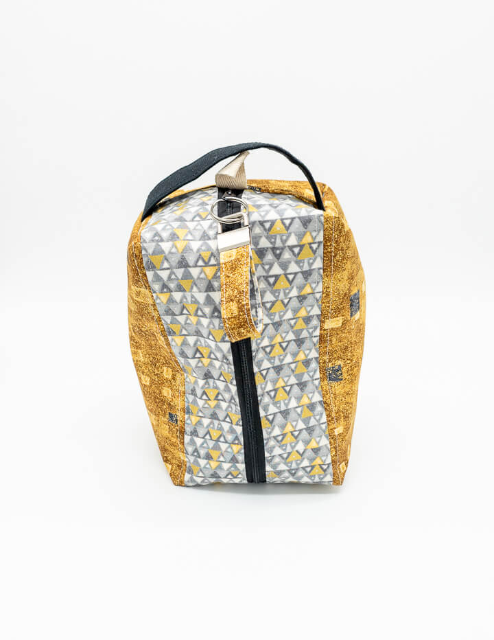 Projekttasche mit geometrischem Muster in Gold und Grau, stilvoll und praktisch zugleich.