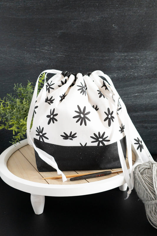 Projekttasche Njord Bag aus Stoff mit Wolle und Stricknadeln auf einem Holztisch arrangiert