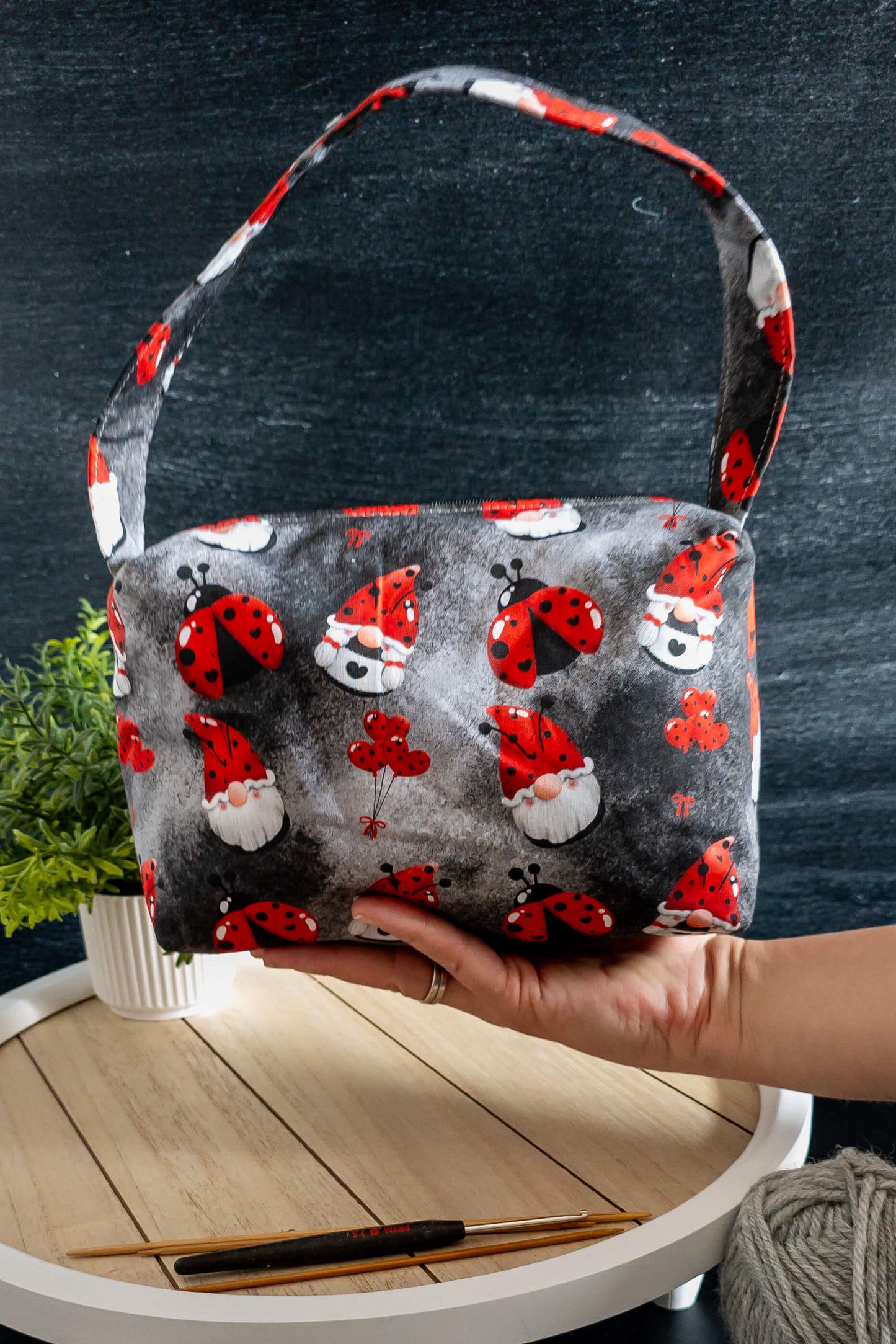 Stricktasche mit praktischem Tragegriff und originellem Glücksmotiv auf dunkelgrauem Baumwollstoff.
