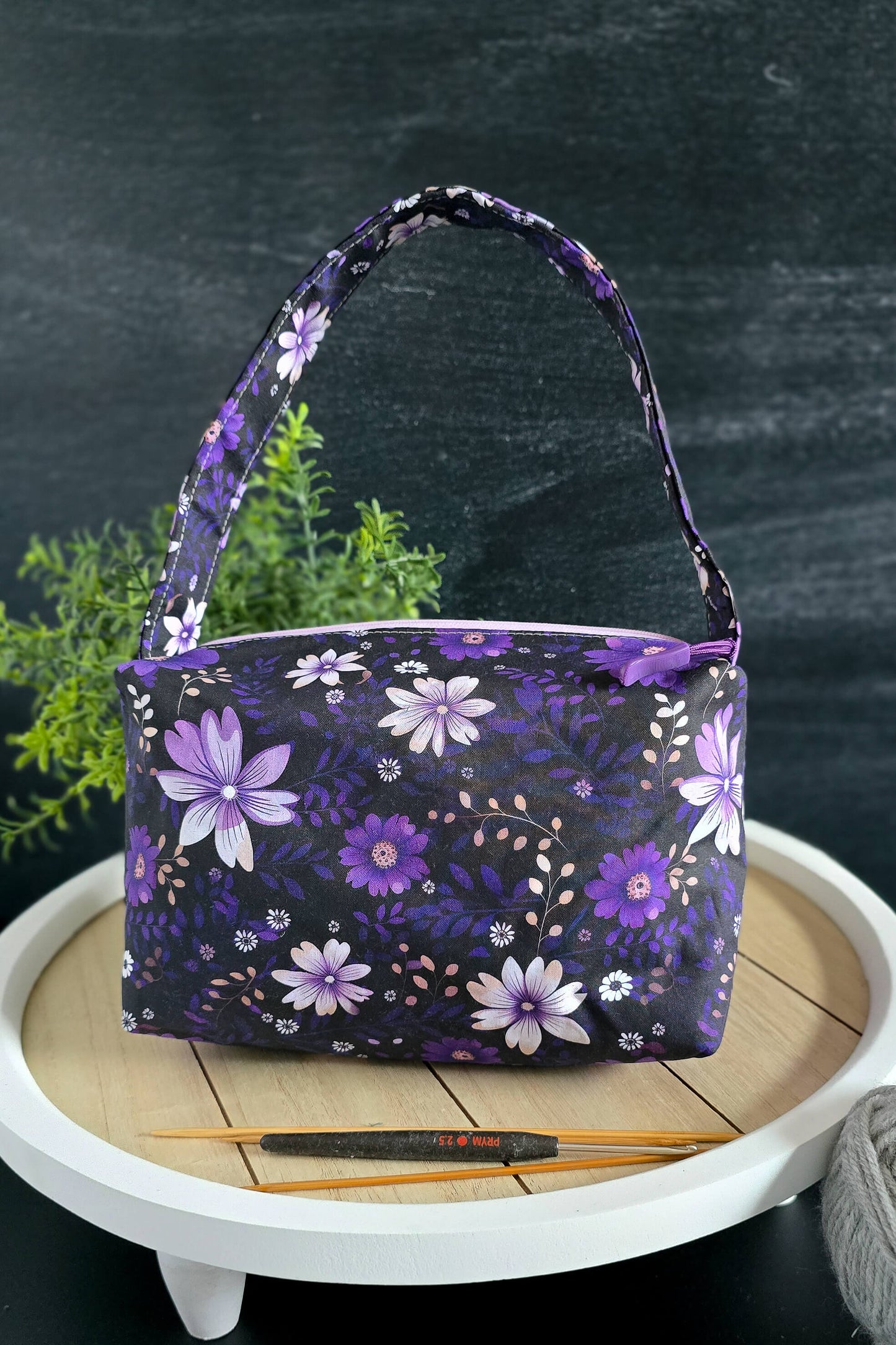 Handgemachte Projekttasche in Lila mit weißen Blumen – perfekt für Strick- und Häkelprojekte.
