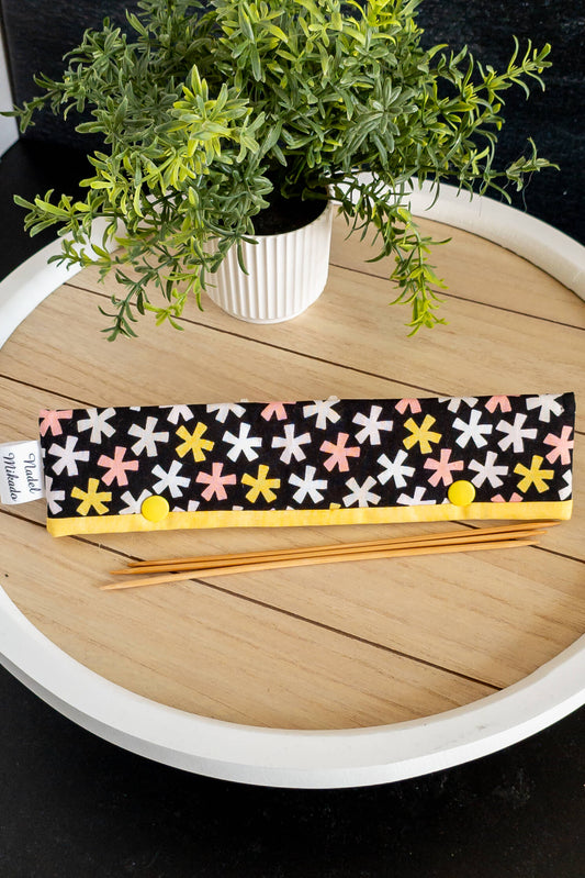 Nahaufnahme der Nadelgarage „Funkelstern“ mit buntem Muster und gelbem Rand, perfekt für 20 cm Stricknadeln