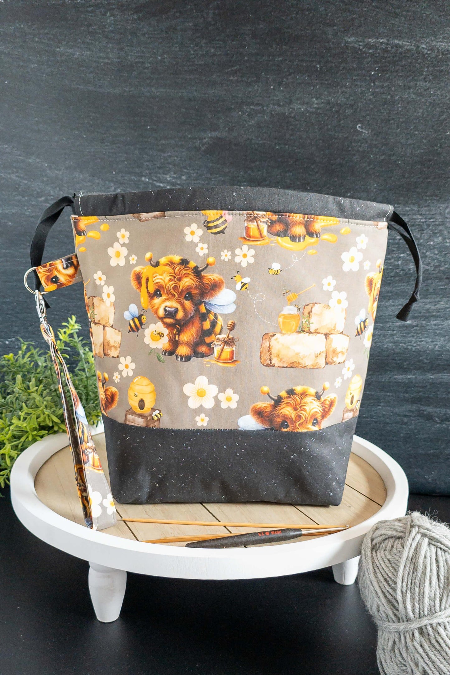 Projektbeutel auf dekorativem Tisch mit Wollknäuel und Häkelnadel – ideal für Wolle & Nadeln