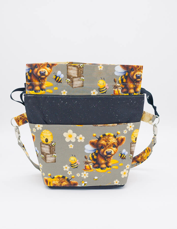 Projekttasche mit farbenfrohem Bienenmotiv und funktionalen Details für kreative Handarbeitsprojekte.