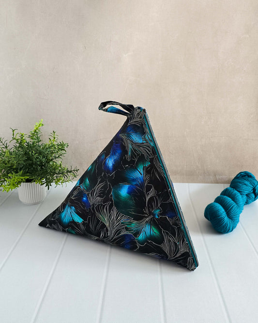 Iska Bag stehend auf weißem Tisch, mit Strang Wolle als Größenvergleich