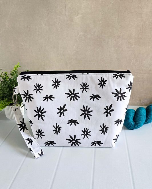 Handgenähte Projekttasche Isvind Daisy mit schwarzem Blumenprint auf weißem Grund