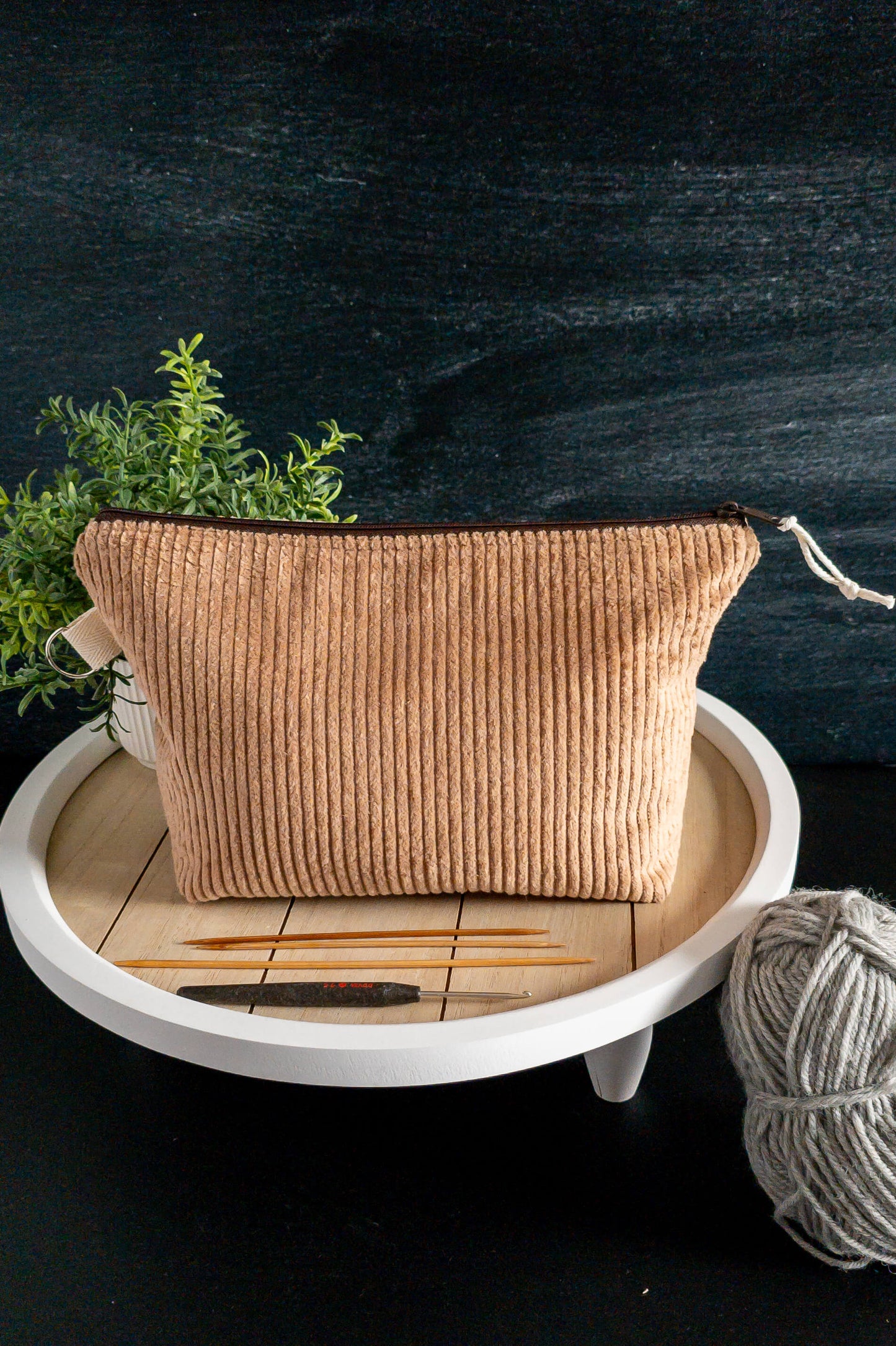 Strickzubehör, Wolle und Häkelnadeln neben der Tasche – dein kreativer Begleiter für unterwegs und zuhause.