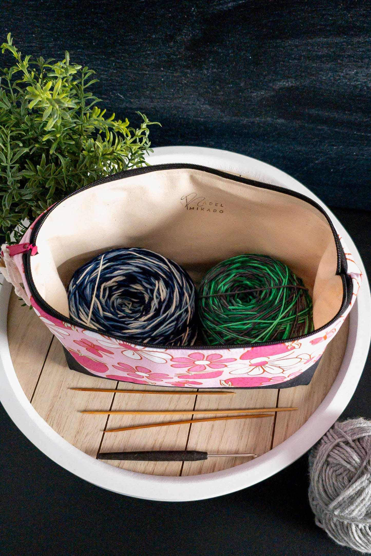 asche auf einem Holztisch dekoriert mit Wolle, Stricknadeln und Pflanzen, ideal für kreative Momente