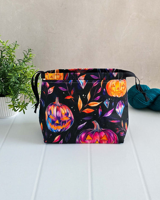 Halloween Projekttaschen – Leuchtende Kürbisse & Kristalle auf schwarzem Hintergrund