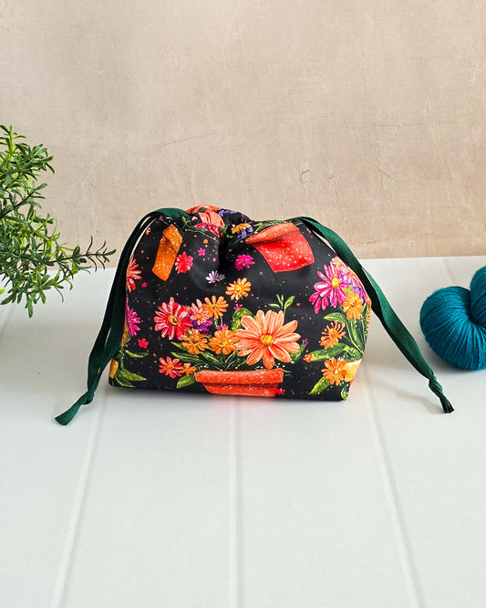 Lyra Projekttasche mit bunten Blumentöpfen auf schwarzem Stoff