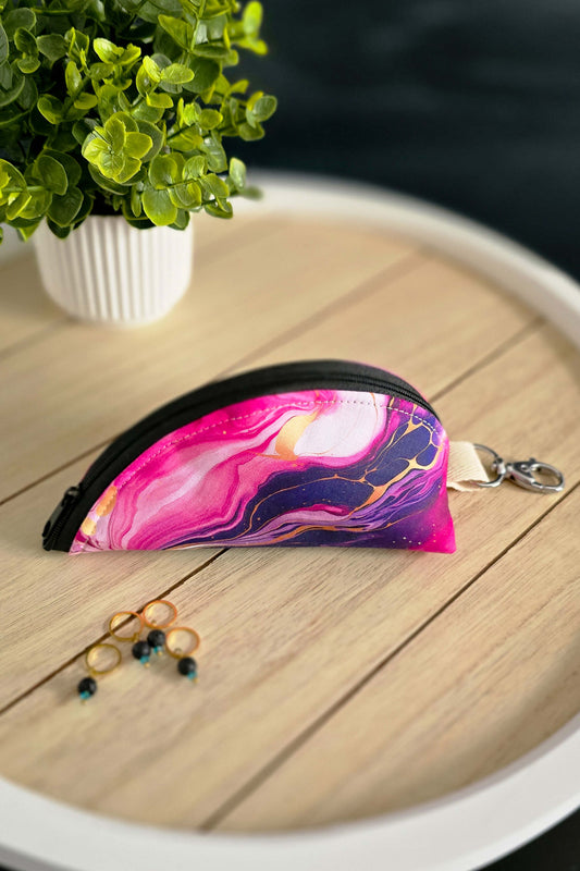 Kleine Stricktasche mit pink-violettem Galaxie-Design auf Holztisch