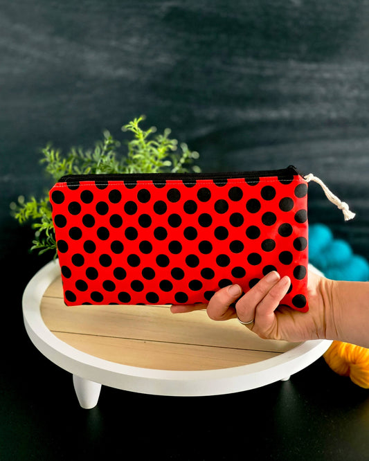 Rote Zubehörtasche mit schwarzen Punkten im Vordergrund