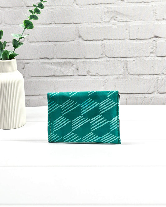 Kleine, flache Mini-Pouch für Strickzubehör mit hellem, grafischem Linienmuster auf smaragdgrünem Stoff, verschlossen mit einer Klappe und einem schwarzen Druckknopf. Handgenäht in Bayern von Nadelmikado.