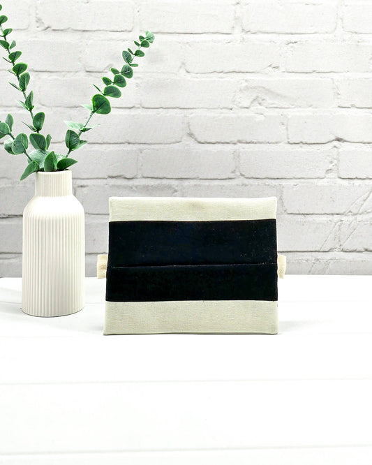Mini Zip Pouch mit breiten horizontalen Streifen in Schwarz und Creme, einem schwarzen mittigen Reißverschluss und hellen Stofflaschen. Handgenäht in Bayern von Nadelmikado.