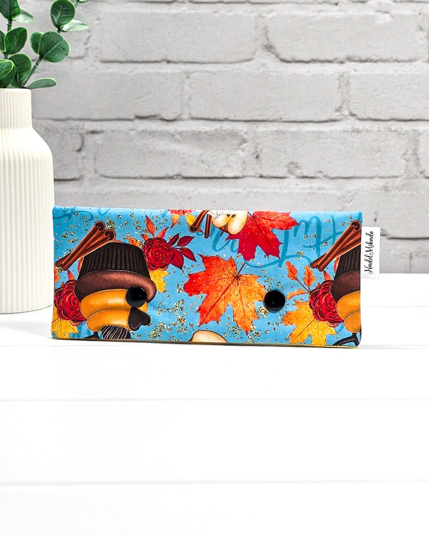 Nadelgarage für 15 cm lange Nadelspiele mit zwei schwarzen Druckknöpfen, Kürbiskuchen, einer Kaffeetasse und herbstlichen Leckereien auf hellblauem Grund. Handgenäht in Bayern von Nadelmikado.