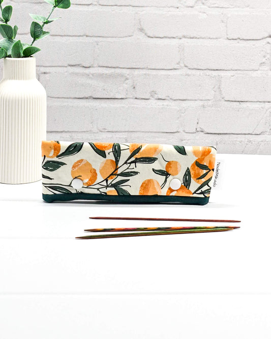 Nadelgarage für 15 cm lange Nadelspiele sichert das Sockenstrickzeug und verhindert fallengelassene Maschen. Botanisches Motiv mit Orangen an grünen Zweigen auf hellem Stoff. Handgenäht in Bayern von Nadelmikado.