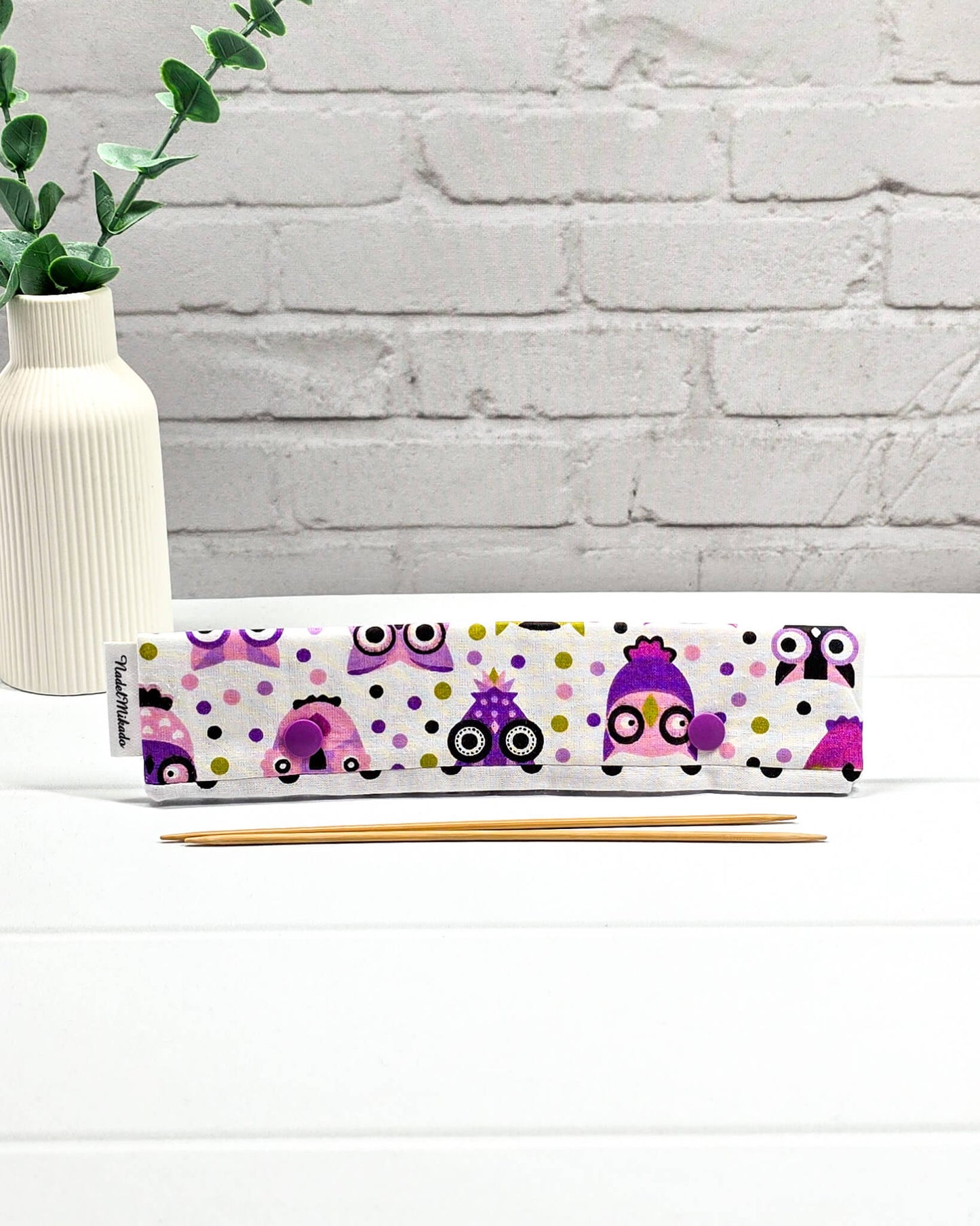 Nadelgarage für 20 cm Nadelspiele mit bunten Eulen-Motiven, lila Druckknöpfen und schwarz-weiß gepunktetem Hintergrund. Handgenäht in Bayern von Nadelmikado