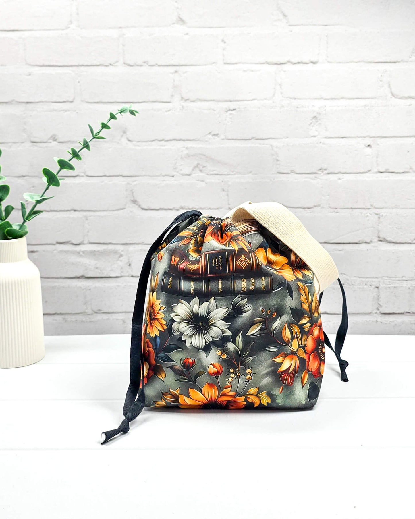 Projekttasche Tuva S mit Vintage-Büchern und floralen Motiven auf dunklem Stoff für Socken- oder Mützenprojekte - handgenäht in Bayern von Nadelmikado