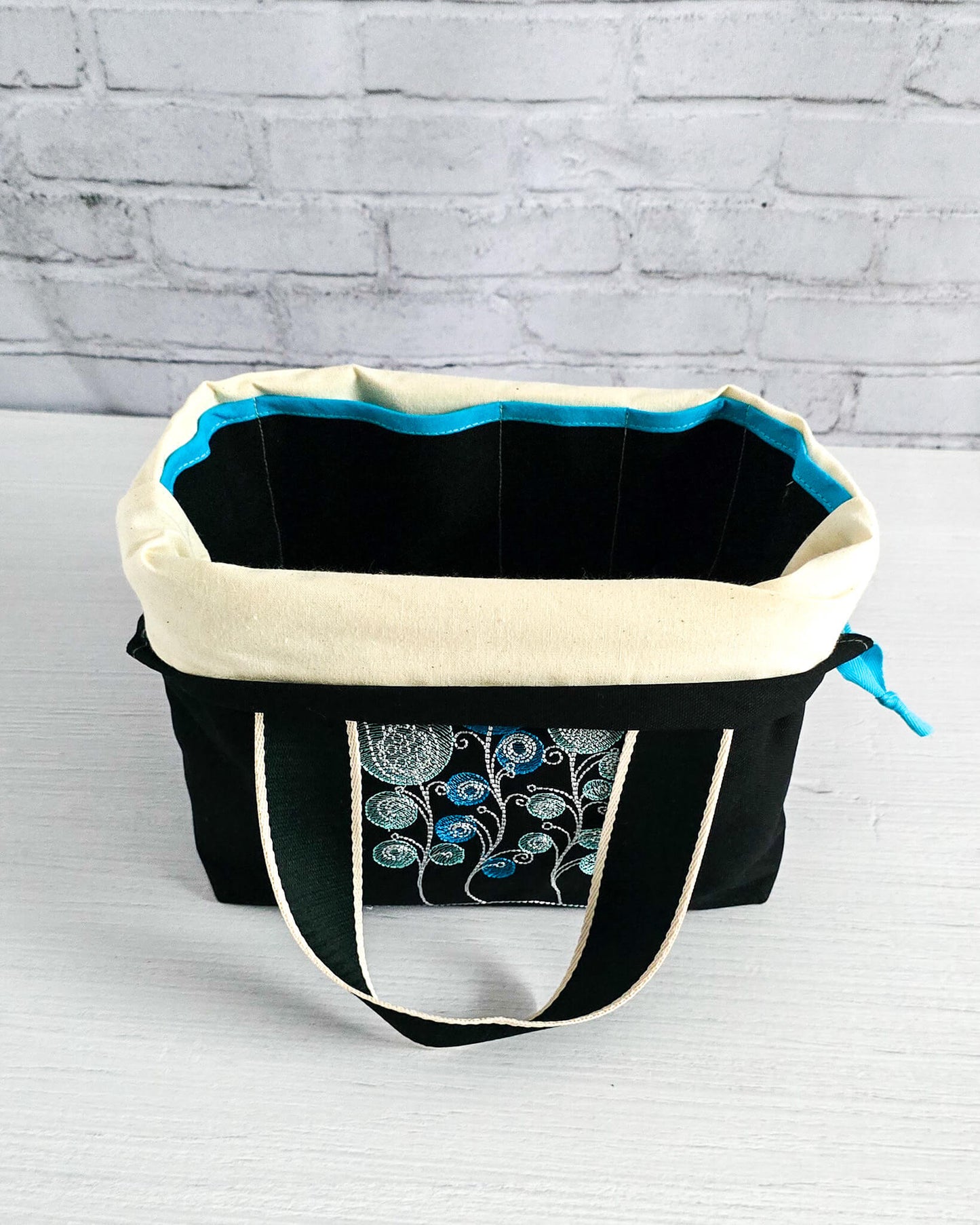 Projekttasche Alva M mit gestickten Blüten auf dunklem Canvas, handgenäht in Bayern von Nadelmikado