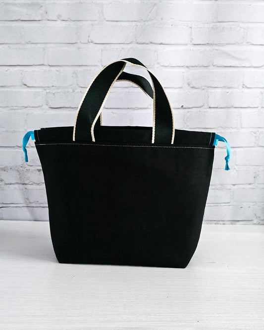 Projekttasche Alva M mit gestickten Blüten auf dunklem Canvas, handgenäht in Bayern von Nadelmikado