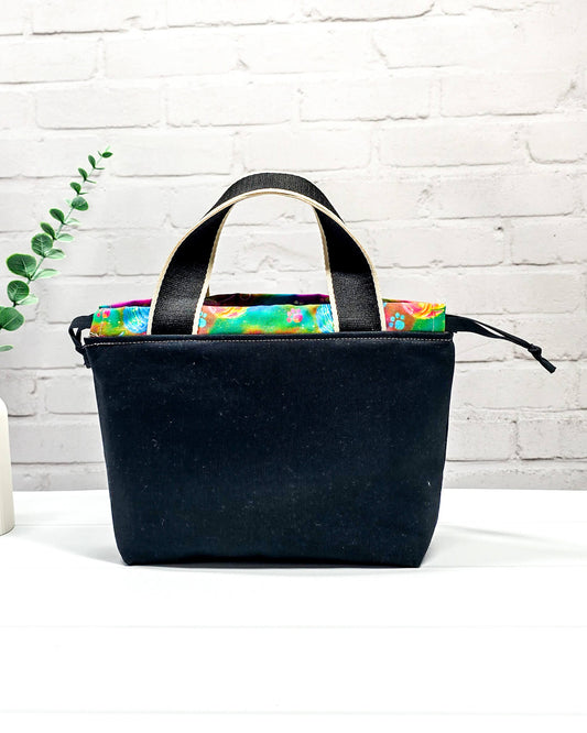 Projekttasche Alva S mit farbigem Strickwichtel auf schwarzem Stoff, handgenäht in Bayern von Nadelmikado