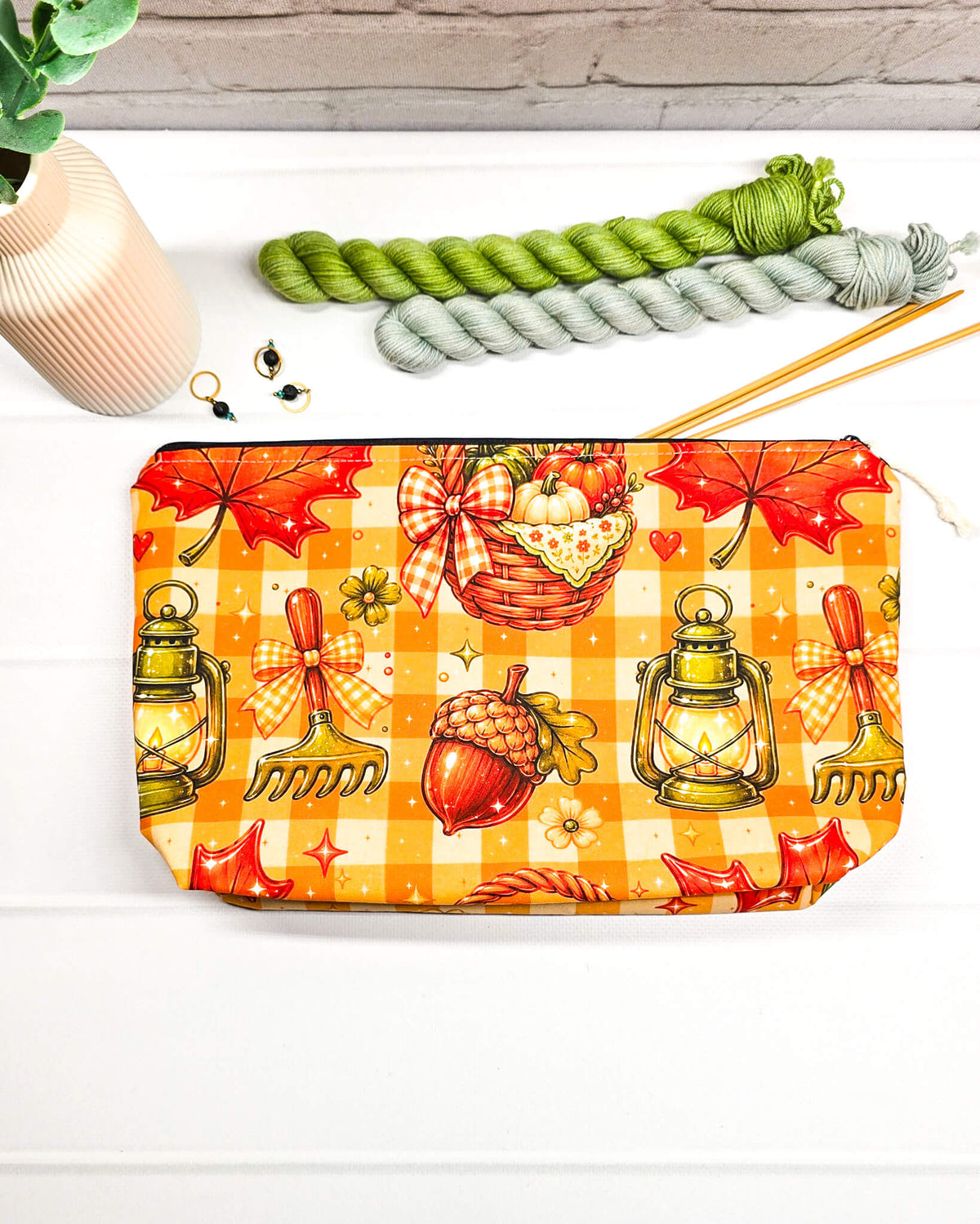 Projekttasche Isvind Größe S mit orangefarbenem Karomuster, Kürbissen, Herbstblättern, Eicheln und leuchtenden Laternen. Reißverschlusstasche für Strickprojekte bis 200 g Wolle. Handgenäht in Bayern von Nadelmikado.