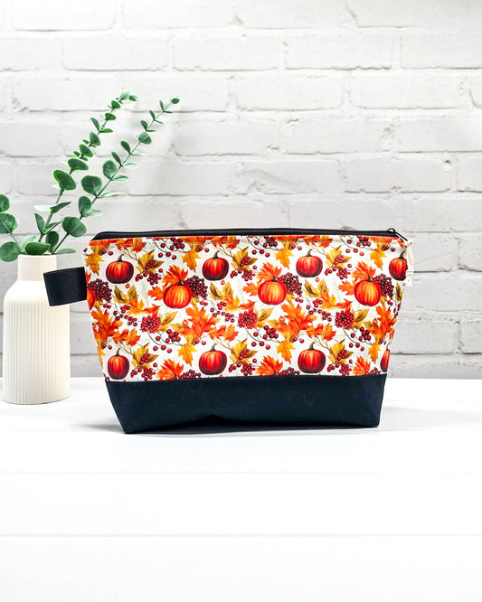Stricktasche mit Kürbis- und Herbstlaub-Motiv, schwarzem Canvas-Boden und Reißverschluss. Platz für 200g Wolle. Handgenäht in Bayern von Nadelmikado.