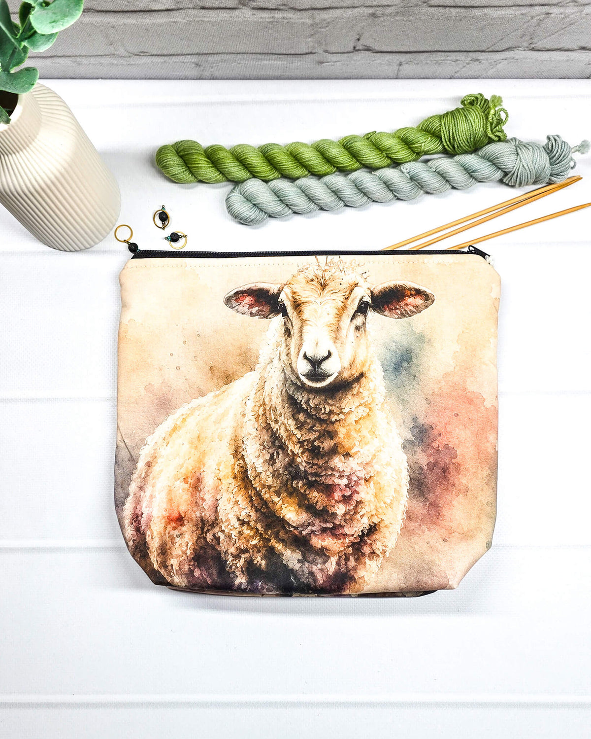 Projekttasche Isvind Größe S mit großem Schafmotiv in sanften Naturtönen auf hellem Hintergrund. Mit Reißverschluss für kleine Strickprojekte. Handgenäht in Bayern von Nadelmikado.