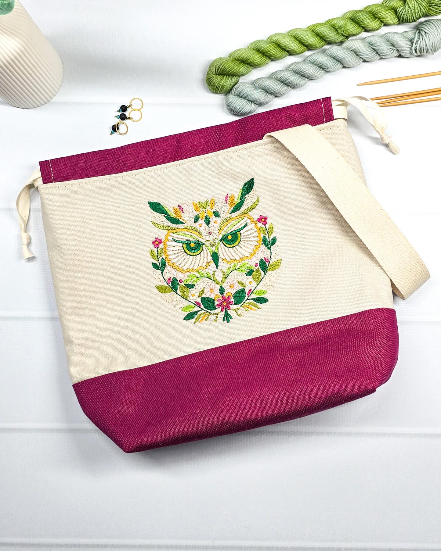 Projekttasche Tuva M aus hellem Canvas und beerefarbenem Stoff mit gesticktem Eulenmotiv, cremefarbenem Kordelzug und Tragegurt. Bietet Platz für 400g Wolle und schützt das Strickzeug vor Verheddern. Handgenäht in Bayern von Nadelmikado.