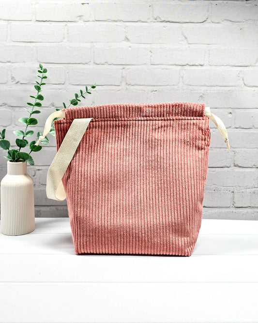 Altrosafarbener Projektbeutel Tuva M aus Cordstoff mit einem hellen Gurtband-Henkel an der Seite und cremefarbenen Kordeln, handgenäht in Bayern von Nadelmikado