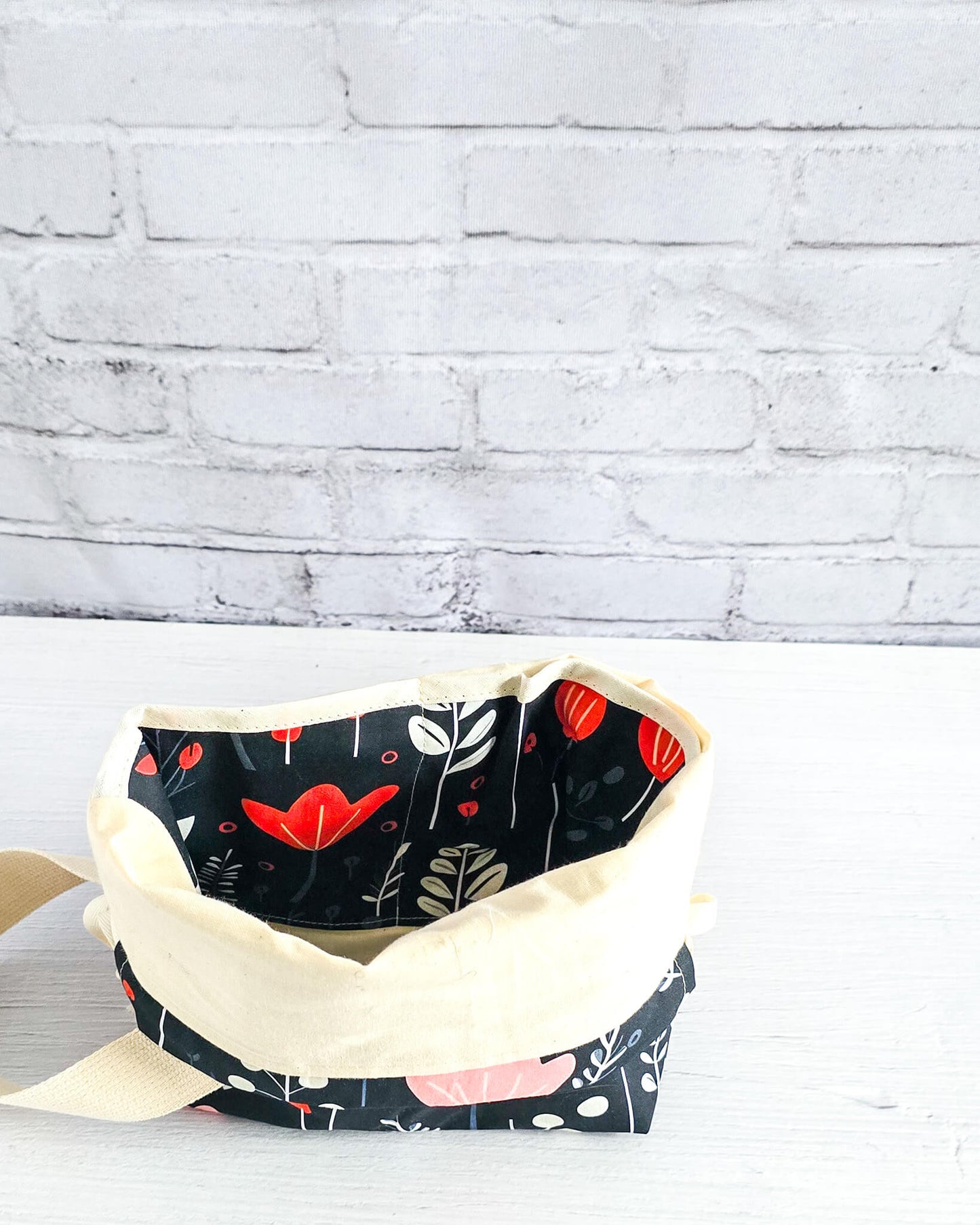 Projekttasche Tuva S Autumn Folk mit grafischem Blumenmuster auf dunklem Stoff - handgenäht in Bayern von Nadelmikado