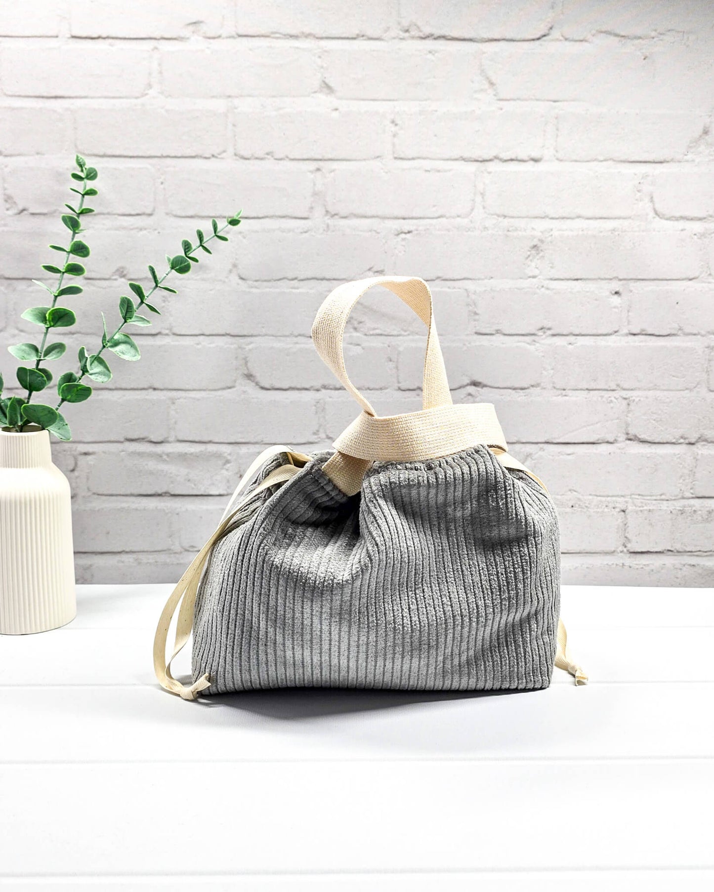 Kleine Stricktasche aus grauem Cordstoff mit zwei hellen Gurtband-Tragegriffen. Handgenäht in Bayern von Nadelmikado