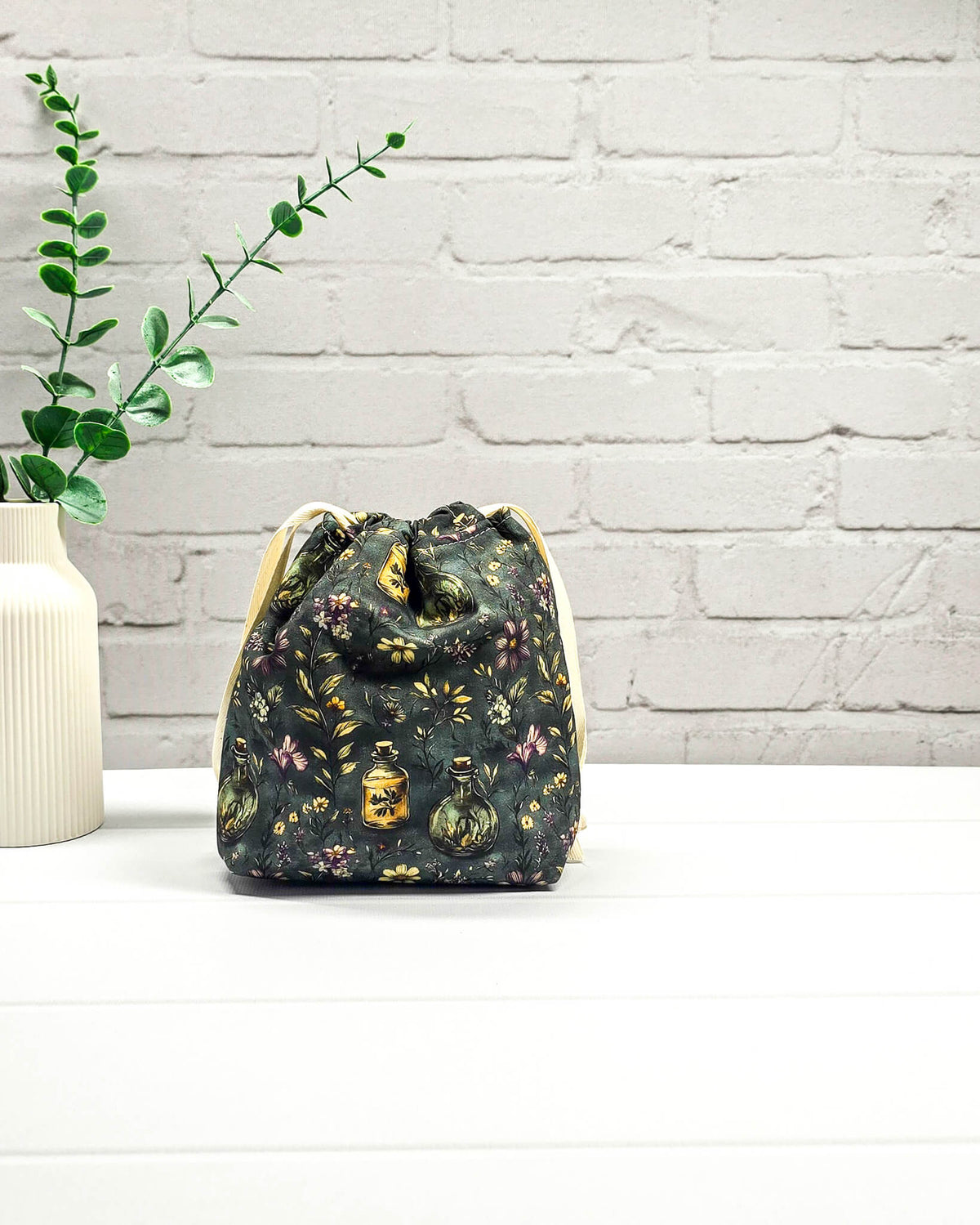 Kleine handgemachte Stricktasche für 50 g Wolle mit dunklem botanischem Muster, Blüten und Apothekerfläschchen. Handgenäht in Bayern von NadelMikado.