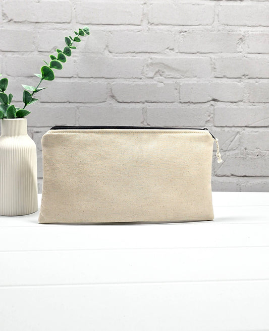 Flache, rechteckige Zip Pouch Runa aus beigem Canvas mit einem großen, blau-gold gestickten Schiffsanker, ideal um Stricknadeln, Seile und Scheren sicher zu verwahren. Handgenäht in Bayern von Nadelmikado