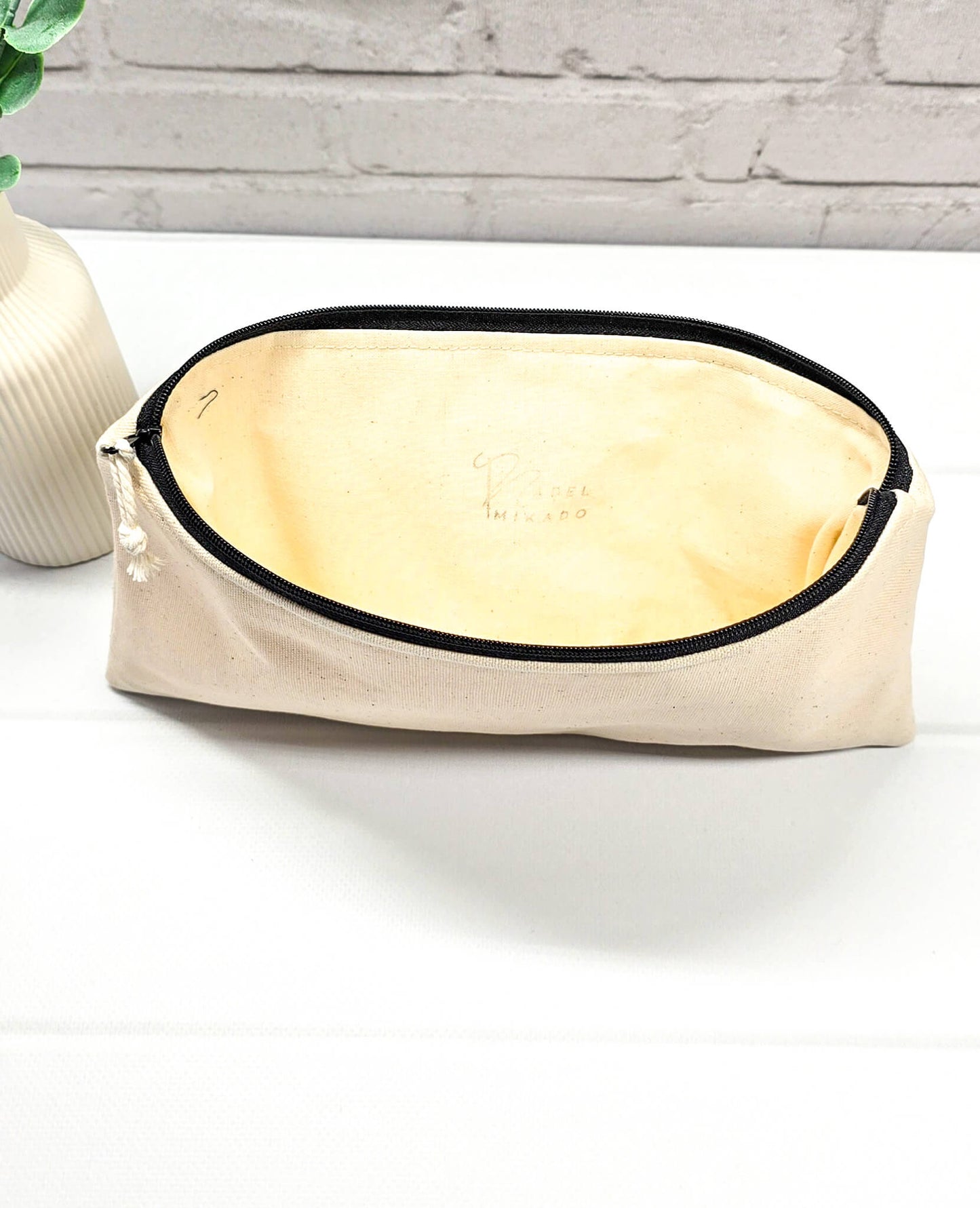 Flache, rechteckige Zip Pouch Runa aus beigem Canvas mit einem großen, blau-gold gestickten Schiffsanker, ideal um Stricknadeln, Seile und Scheren sicher zu verwahren. Handgenäht in Bayern von Nadelmikado