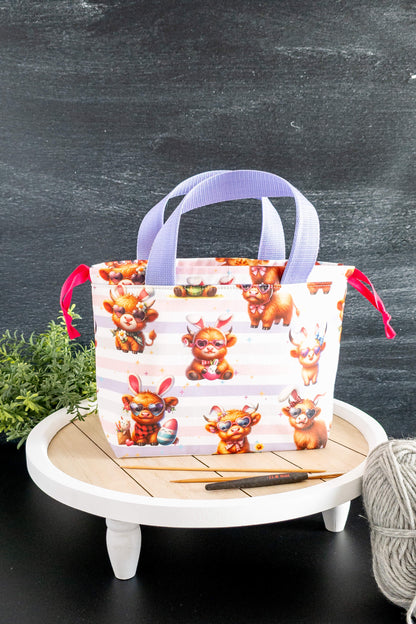 Detailansicht des bunten Baumwollstoffs mit niedlichen Tiermotiven auf pastellfarbenem Hintergrund.