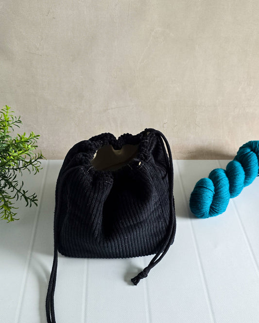 Schwarze Projekttasche aus Cord mit Kordelzug – für bis zu 400 g Wolle. Handgenäht & edel.