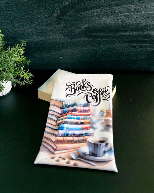 Handgenähte Buchhülle mit Stapel bunter Bücher und Kaffeetasse