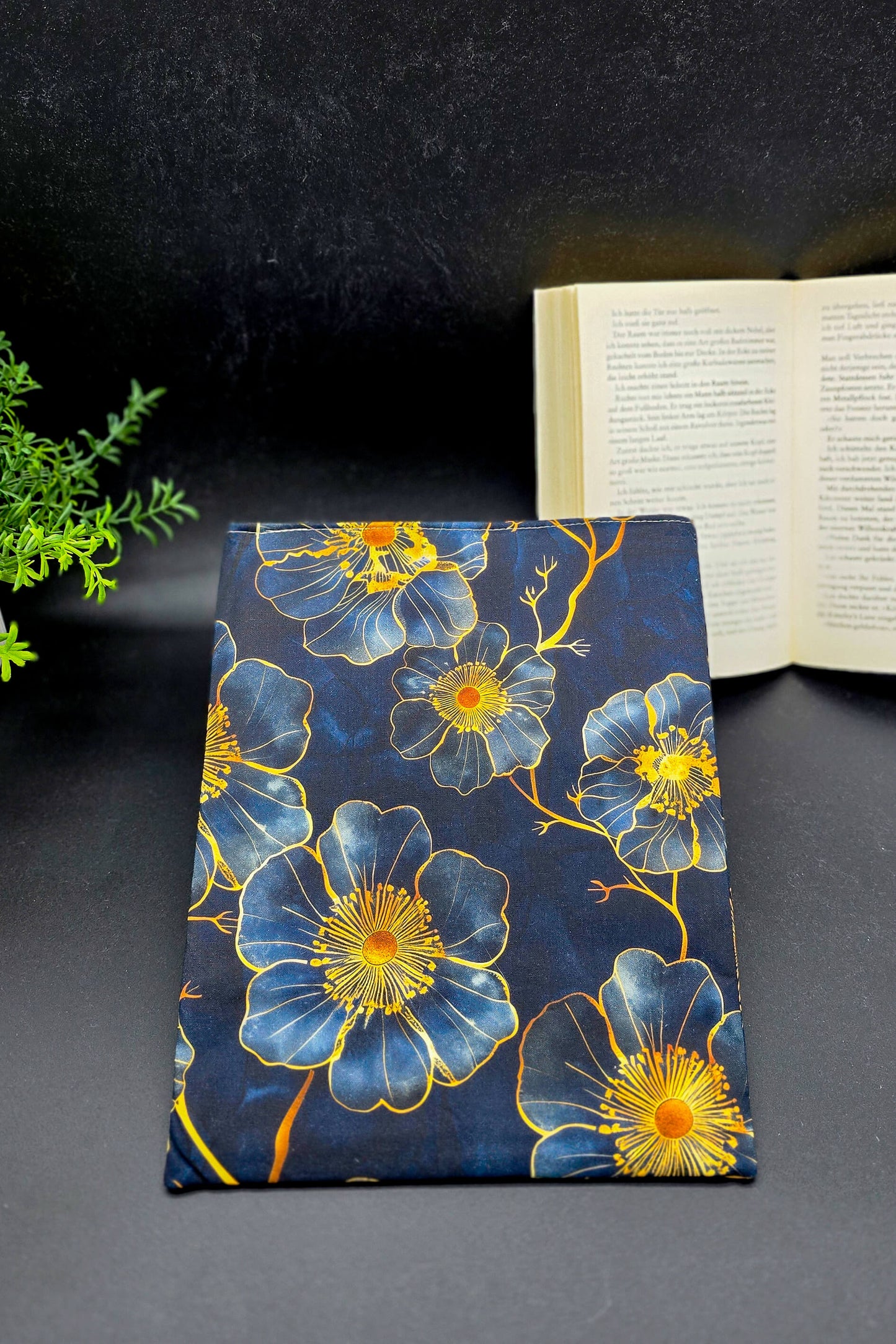 Handgemachte Buchhülle mit dunkelblauem Stoff und goldenen Blüten, passend für Taschen- und Hardcoverbücher