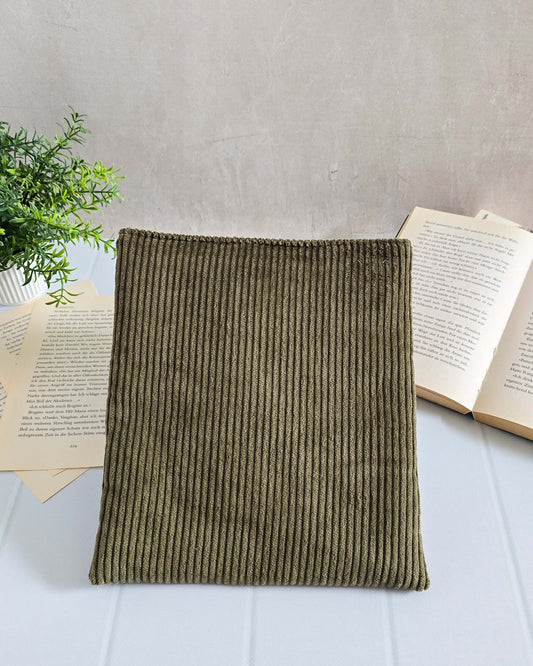 Olivgrüne Buchhülle aus Cordstoff, frontal vor aufgeschlagenem Buch fotografiert