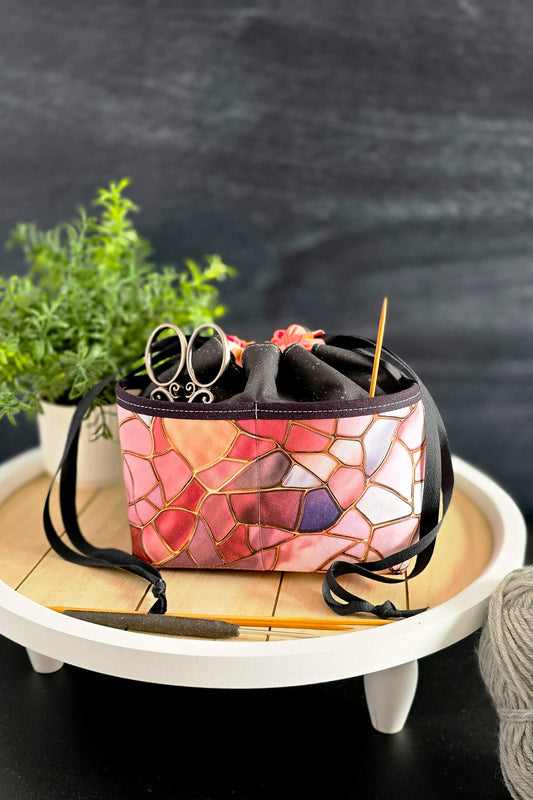 handgenähte Projekttasche „Mosaikzauber“ mit kunstvollem Mosaikmuster, gefüllt mit Strickzubehör, stilvoll präsentiert auf einem Holztisch