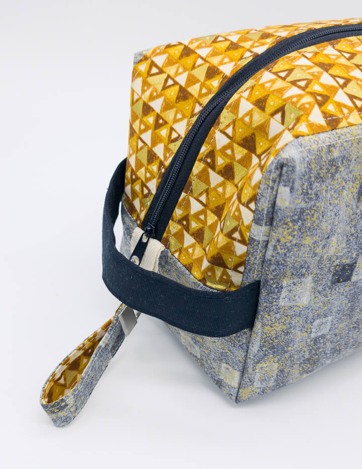 Detailaufnahme des geometrischen goldenen Musters auf der Fenja Boxy Bag, perfekt für Wolle und Kosmetik.